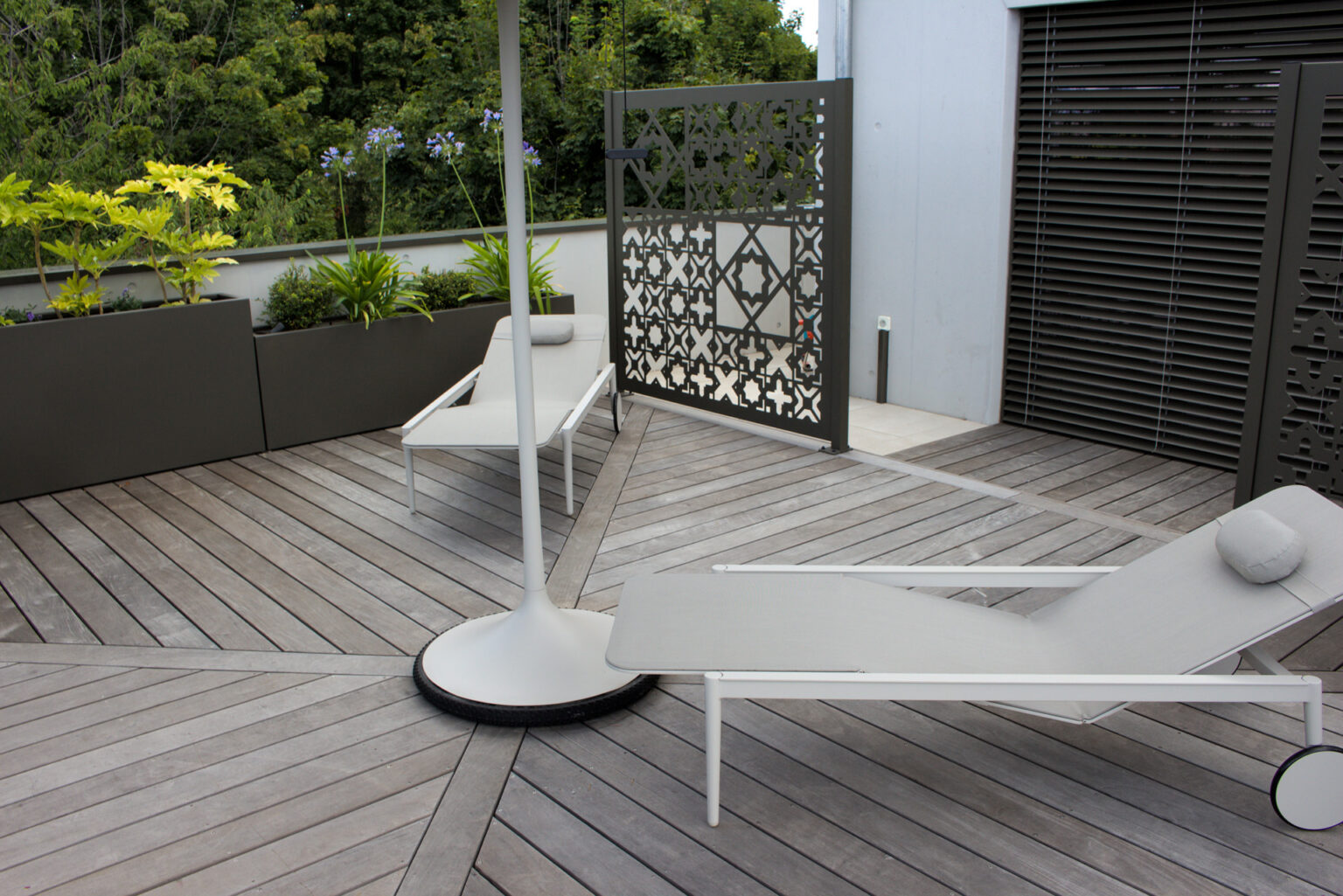 Terrasse ipé en chevrons avec bains de soleil, claustra façon moucharabieh et bacs alu laqués – projet ACER