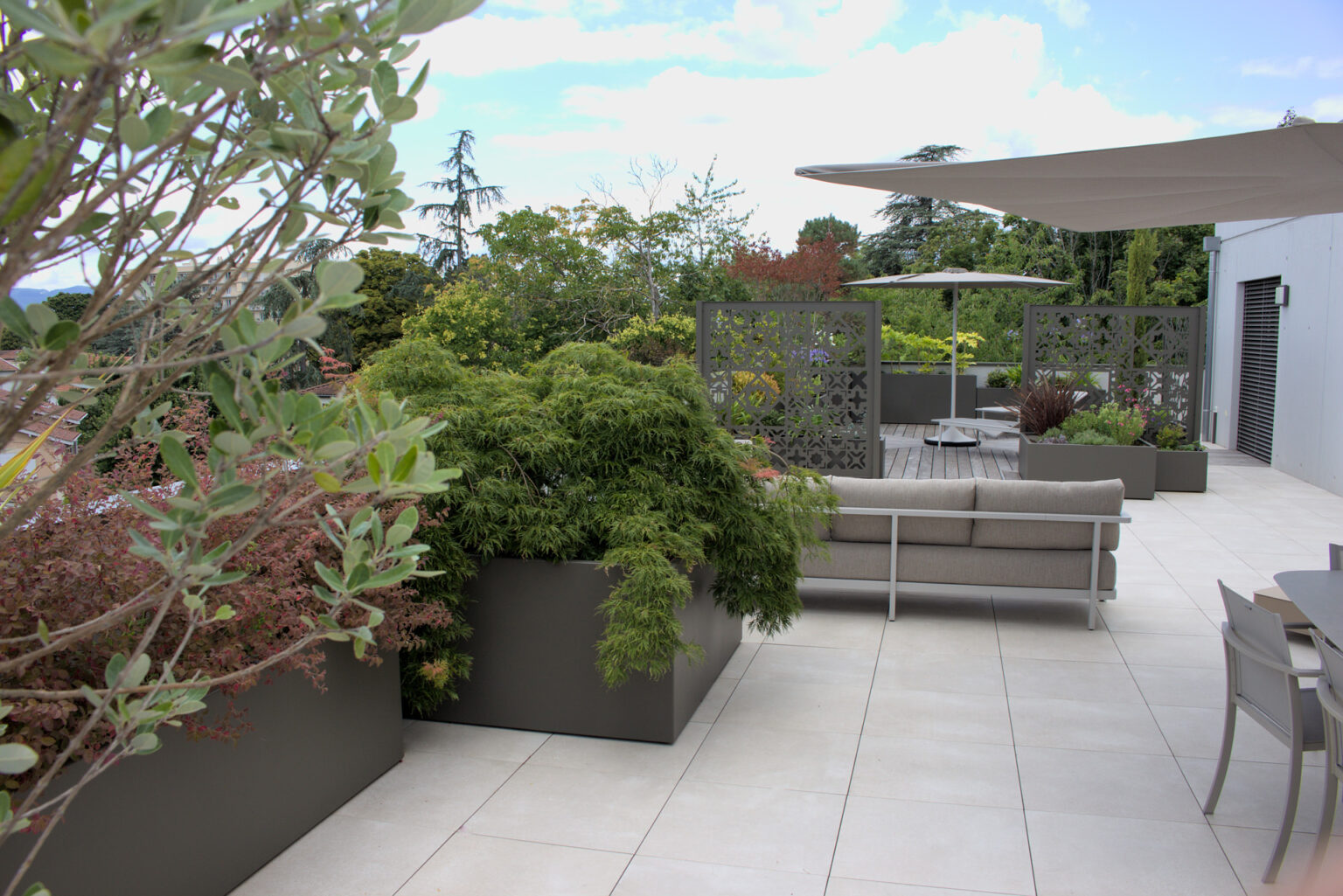 Terrasse de toit dallée, bacs alu laqués plantés d'érable du Japon, voile d'ombrage et claustras – projet ACER