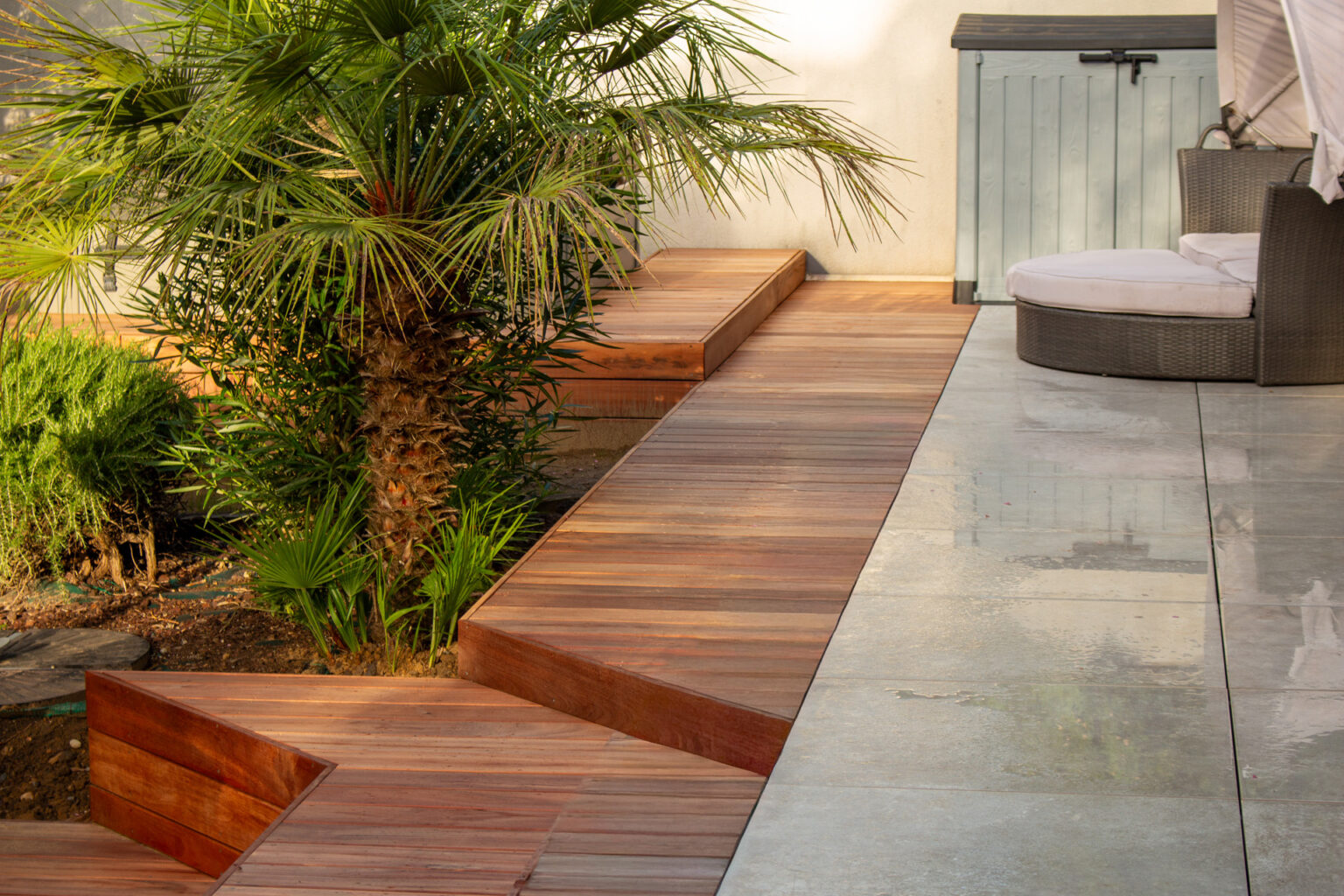 Banquette en bois exotique au pied du palmier, terrasse en grès cérame mouillée et lit de jour – projet LAVANDULA