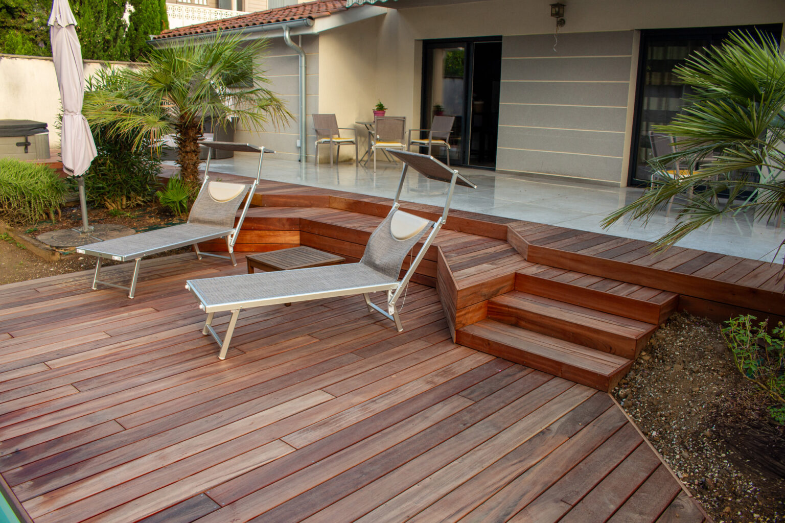 Plage en bois exotique avec banquettes et escalier vers la terrasse en grès cérame, bains de soleil – projet LAVANDULA